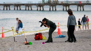 Investigators on the beach in Lauderdale-by-the-Sea, Fla., take photos of the scene of a sand collapse on Tuesday, Feb. 20, 2024. A young girl was buried in sand and died Tuesday when a deep hole she was digging with a little boy collapsed on them both at a south Florida beach, authorities said. (Mike Stocker/South Florida Sun-Sentinel via AP)