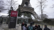 Tour Eiffel employees talks to visitors at the Eiffel Tower, Tuesday, Feb. 20, 2024 in Paris. Visitors to the Eiffel Tower were turned away for the second consecutive day because of a strike over poor financial management at one of the world's most-visited sites. (AP Photo/Michel Euler).