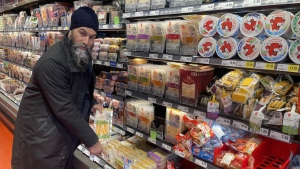 NDP Leader Jagmeet Singh points to a $20 package of cheese during a visit to a Loblaws grocery store in Ottawa on Wednesday Feb. 21, 2024. Singh has made it a central tenet of his party's policy to take on big companies he believes are making record profits while ordinary people struggle to afford the basics. THE CANADIAN PRESS/Mickey Djuric
