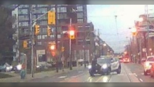 A Toronto woman is unimpressed after a police car turned and ran into her while she was crossing the street – an encounter caught on dashcam video by another driver.