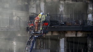 Firefighters work at a burned block building in Valencia, Spain, Friday, Feb. 23, 2024. (AP Photo/Alberto Saiz)