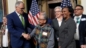 Washington Gov. Jay Inslee, left, shakes hands with Chair Gerry Lewis of the Yakama Nation, following a ceremonial signing ceremony in Washington, Friday, Feb. 23, 2024, as Oregon Gov. Tina Kotek, third from right, Chair of the Council on Environmental Quality Brenda Mallory, second from right, and Chair Shannon Wheeler of the Nez Perce Tribe, right, watch. The ceremonial signing is an agreement between the Biden administration and state and Tribal governments to work together to protect salmon and other native fish, honor obligations to Tribal nations, and recognize the important services the Columbia River System provides to the economy of the Pacific Northwest. (AP Photo/Susan Walsh)