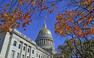 The West Virginia Capitol with its dome framed by turning sugar maples leaves is seen, Nov. 3, 2014, in Charleston, W.Va. Close to 400 medical professionals in West Virginia have signed onto a letter condemning a bill advancing in the state House of Delegates that would bar transgender youth at risk for suicide from accessing medical interventions like hormone therapy. (Tom Hindman/The Daily Mail via AP, File)