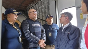 Migration officials meet former Colombian paramilitary leader Salvatore Mancuso at the gate of the plane at El Dorado International Airport in Bogota, Colombia, Tuesday, Feb. 27, 2024. (Colombian Immigration Agency via AP)