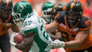 Saskatchewan Roughriders' Greg Morris, left, carries the ball past B.C. Lions' Craig Roh during the first half of a CFL football game in Vancouver, B.C., on Saturday August 5, 2017. Defensive lineman Craig Roh, who won a Grey Cup with the Winnipeg Blue Bombers in 2019, has died. THE CANADIAN PRESS/Darryl Dyck