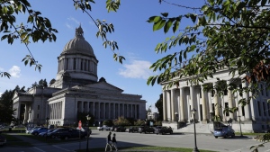 The afternoon sun illuminates the Legislative Building, left, at the Capitol in Olympia, Wash, Oct. 9, 2018. The Washington state House has overwhelmingly approved legislation that would ban police from hog-tying suspects, a restraint technique that has long drawn concern due to the risk of suffocation. The vote on Wednesday, Feb. 28, 2024 came nearly four years after Manuel Ellis, a 33-year-old Black man, died in Tacoma, Wash., facedown with his hands and feet cuffed together behind him. (AP Photo/Ted S. Warren, File)