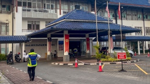 A security officer walks outside the Sultanah Maliha Hospital, where King Harald V of Norway is believed to be admitted with an infection, on the Malaysian resort island of Langkawi, Malaysia, Wednesday, Feb. 28, 2024. Malaysian national news agency Bernama cited unidentified sources as confirming that Europe's oldest monarch was warded at the hospital’s Royal Suite. (AP Photo/Vincent Thian)