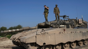 Israeli soldiers stand on their tank in a staging area near the Israel-Gaza border in southern Israel, Wednesday, Feb. 28, 2024. (AP Photo/Tsafrir Abayov)