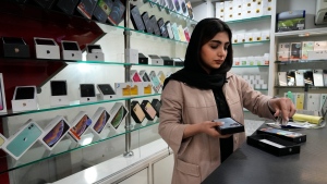 A cellphone vendor works at her shop in downtown Tehran, Iran, Wednesday, Feb. 21, 2024. (AP Photo/Vahid Salemi)