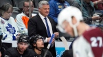 Toronto Maple Leafs head coach Sheldon Keefe, back, looks on from the team box in the second period of an NHL hockey game against the Colorado Avalanche Saturday, Feb. 24, 2024, in Denver. The NHL has fined Keefe US$25,000 for "unprofessional conduct directed at the officials." THE CANADIAN PRESS/AP-David Zalubowski
