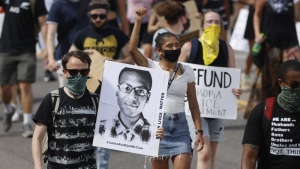 Demonstrators carry placards as they walk down Sable Boulevard during a rally and march over the death of Elijah McClain in Aurora, Colo., June 27, 2020. (David Zalubowski/AP Photo)