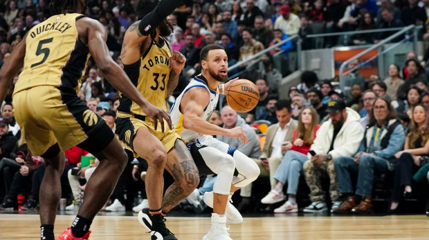 Golden State Warriors guard Stephen Curry (30) protects the ball from Toronto Raptors guard Gary Trent Jr. (33) during first half NBA basketball action in Toronto on Friday, March 1, 2024. THE CANADIAN PRESS/Arlyn McAdorey