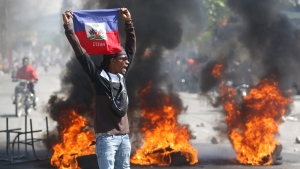 A demonstrator holds up an Haitian flag during protests demanding the resignation of Prime Minister Ariel Henry in Port-au-Prince, Haiti, Friday, March 1, 2024. (Odelyn Joseph / AP Photo)
