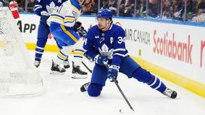 Toronto Maple Leafs forward Auston Matthews (34) controls the puck as he stumbles against the Buffalo Sabres during first period NHL hockey action in Toronto on Wednesday, March 6, 2024. THE CANADIAN PRESS/Nathan Denette