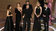 Raney Aronson-Rath, from left, Vasilisa Stepanenko, Mstyslav Chernov, Evgeniy Maloletka, Michelle Mizner, and Derl McCrudden accept the award for best documentary feature film for "20 Days in Mariupol" during the Oscars on Sunday, March 10, 2024, at the Dolby Theatre in Los Angeles. (AP Photo/Chris Pizzello)