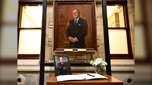 A photograph and book of condolences for Members of Parliament to sign are seen in front of the official portrait of former prime minister Brian Mulroney, in the antechamber to the House of Commons on Parliament Hill as Canadians mourn his death on Thursday at the age of 84, in Ottawa, Friday, March 1, 2024. THE CANADIAN PRESS/Justin Tang
