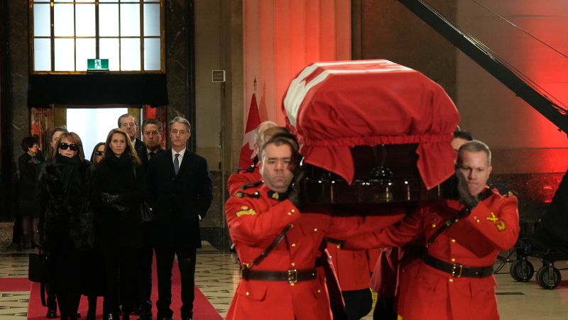 Members of the Mulroney family follow as an honour guard carries the casket of former prime minister Brian Mulroney into the Sir John A. Macdonald building opposite Parliament Hill in Ottawa on Tuesday, March 19, 2024. THE CANADIAN PRESS/Adrian Wyld