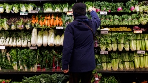 A customer shops for produce at a grocery store In Toronto on Friday, Feb. 2, 2024. (Cole Burston / The Canadian Press)