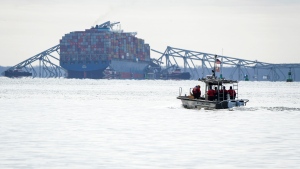 A U.S. Coast Guard boat heads toward the collapsed Francis Scott Key Bridge wreckage seen from Ft. McHenry, Md., on Tuesday, March 26, 2024. The bridge collapsed early Tuesday morning when a cargo ship collided with it. (Ulysses MuÃ±oz/The Baltimore Banner via AP)