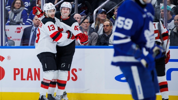 New Jersey Devils defenceman Luke Hughes (43) and centre Nico Hischier (13) celebrate Hughes' goal against the Toronto Maple Leafs during first period NHL hockey action in Toronto on Tuesday, March 26, 2024. THE CANADIAN PRESS/Cole Burston