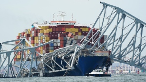 A cargo ship is stuck under the part of the structure of the Francis Scott Key Bridge after the ship his the bridge Tuesday March 26, 2024, in Baltimore, Md. (AP Photo/Steve Helber)