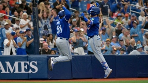 Toronto Blue Jays' Justin Turner, right, celebrates with third base coach Carlos Febles after a solo home run off Tampa Bay Rays' Tyler Alexander during the fifth inning of a baseball game Sunday, March 31, 2024, in St. Petersburg, Fla. (AP Photo/Steve Nesius)