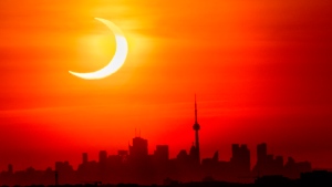 A partial solar eclipse rises over the skyline of Toronto on Thursday, June 10, 2021. THE CANADIAN PRESS/Frank Gunn

