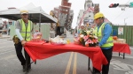 Workers set up offerings before the demolition ceremony in front of the building seen partially collapsed, two days after a powerful earthquake struck the city, in Hualien City, eastern Taiwan, Friday, April 5, 2024. (AP Photo/Chiang Ying-ying)