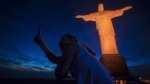 FILE - A tourist takes a selfie with the Christ the Redeemer statue in Rio de Janeiro, Brazil, Nov. 25, 2017. Brazil’s government has postponed until April 2025 tourist visa exemptions for citizens of the U.S., Australia, and Canada that had been scheduled to end on Wednesday, according to a decree published in the nation's official gazette. (AP Photo/Bruna Prado, File)