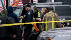 Toronto Police alongside Paramedics and Firefighters work the scene where a police officer was stabbed and a suspect shot in Toronto on Friday, April 12, 2024. THE CANADIAN PRESS/Arlyn McAdorey