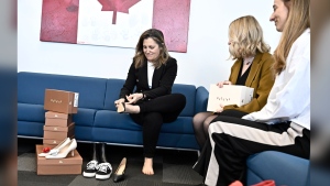 Deputy Prime Minister and Minister of Finance Chrystia Freeland tries on a pair of shoes from direct-to-consumer footwear company Maguire during a pre-budget photo op in her office in Ottawa, Monday, April 15, 2024. THE CANADIAN PRESS/Justin Tang