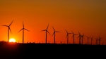 The sun sets behind wind mills on a farm Wednesday, Feb. 28, 2024, in Prairie Township, Ind. (AP Photo/Kiichiro Sato)