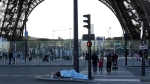 A homeless person sleeps just next to the Eiffel Tower Wednesday, April 10, 2024 in Paris. (AP Photo/Laurent Cipriani , File) 