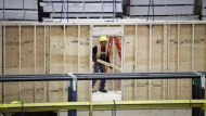 An employee works on a modular home component in Calgary, Friday, April 5, 2024. THE CANADIAN PRESS/Jeff McIntosh