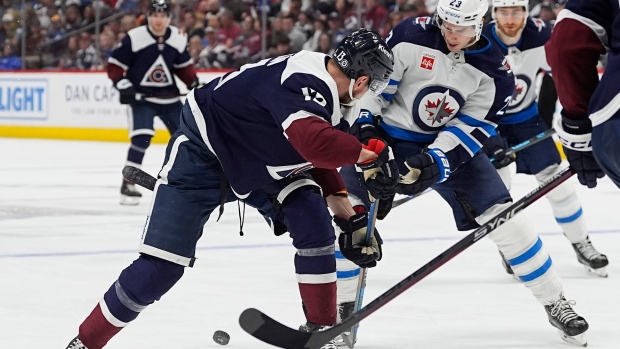 Colorado Avalanche right wing Valeri Nichushkin, left, becomes entangled with Winnipeg Jets centre Sean Monahan (23) in the third period of an NHL hockey game Saturday, April 13, 2024, in Denver. (AP Photo/David Zalubowski)
