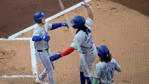 Toronto Blue Jays' Daulton Varsho, left, celebrates with teammates Vladimir Guerrero Jr., center, and Bo Bichette, after hitting a three-run home run during the first inning of a baseball game against the San Diego Padres, Saturday, April 20, 2024, in San Diego. (AP Photo/Gregory Bull)