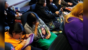 Dorothy Sakanee, second from left, hangs her head as she holds a photo of her granddaughter Mackenzie Moonias, a 14-year-old found dead in Thunder Bay in December, 2023, during a press conference calling for the disbandment of the Thunder Bay Police Services at Queen's Park in Toronto, Monday, April 22, 2024. THE CANADIAN PRESS/Cole Burston