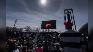 People watch the total solar eclipse at Parc Jean Drapeau, in Montreal, Monday, April 8, 2024. THE CANADIAN PRESS/Ryan Remiorz