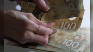 All Canadian households across the economic spectrum saw a surge in both income and wealth since the pre-pandemic time but a report suggests a gap between the highest earners and low-income groups has widened to a level not seen since 2015. Canadian $100 bills are counted in Toronto, Feb. 2, 2016. THE CANADIAN PRESS/Graeme Roy