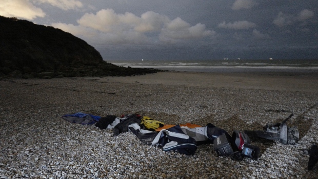 Life jackets, sleeping bags and a damaged inflatable small boat are pictured on the shore in Wimereux, northern France, Friday, Nov. 26, 2021 in Calais, northern France. (AP Photo/Rafael Yaghobzadeh)