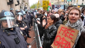 FILE - Police in Riot gear stand guard as demonstrators chant slogans outside the Columbia University campus, Thursday, April 18, 2024, in New York. (AP Photo/Mary Altaffer, File)