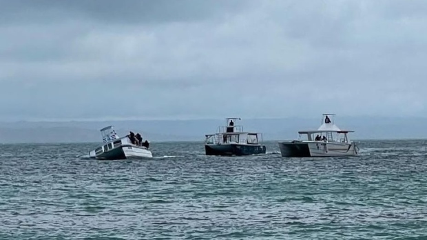 The boat to the left began taking on water while at sea after being struck by a log in the ocean on April 15, 2024, tourism group Grupo Pinero, says. One passenger took photos before being rescued by a relief boat. (Photo submitted by Brock MacKenzie). 