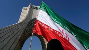 A huge Iranian flag is carried under the Azadi (Freedom) monument tower during the annual rally commemorating Iran's 1979 Islamic Revolution in Tehran, Iran, Sunday, Feb. 11, 2024. (Vahid Salemi / AP Photo)