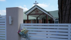 Flores sit on a fence outside the Christ the Good Shepherd church in suburban Wakely in western Sydney, Australia, on April 16, 2024. (AP Photo/Mark Baker, File)