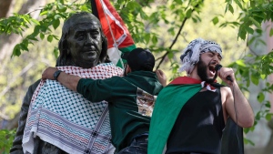 Qais Dana protests as a person puts a scarf on a Ben Franklin statue on Penn's campus during a pro-Palestinian demonstration in Philadelphia on Thursday, April 25, 2024. (Elizabeth Robertson/The Philadelphia Inquirer via AP)