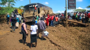 People gather around a bus that was swept away after a dam burst, in Kamuchiri Village Mai Mahiu, Nakuru County, Kenya, Monday, April 29, 2024. (AP Photo/Patrick Ngugi)