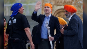 Prime Minister Justin Trudeau waves to the crowd after receiving a ceremonial sabre, called a "talwar" in the Punjabi language, as a special gift from the Ontario Sikhs and Gurudwara Council after speaking during Khalsa day celebrations at City Hall in Toronto, Sunday, April 28, 2024. THE CANADIAN PRESS/Cole Burston