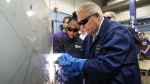 Ontario Premier Doug Ford, right, gets help from grade 11 student Shannon Williams, 16, as they practise welding at St. Mary Catholic Secondary School in Pickering, Ont., on Wednesday, March 8, 2023. THE CANADIAN PRESS/Nathan Denette