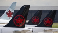 Air Canada logos are seen on the tails of planes at the airport in Montreal, Monday, June 26, 2023. Air Canada reported a loss of $81 million in its first-quarter as its operating revenue rose seven per cent. THE CANADIAN PRESS/Adrian Wyld
