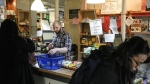 Store manager Zachary Weingarten helps members cash out at the Karma Co-op Food Store in Toronto, Friday, March 15, 2024. The co-op focuses on local, organic and ethically produced foods, with many products available in bulk for zero-waste shoppers. THE CANADIAN PRESS/Chris Young